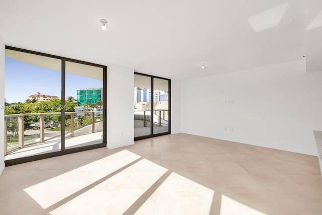 empty room featuring expansive windows and plenty of natural light