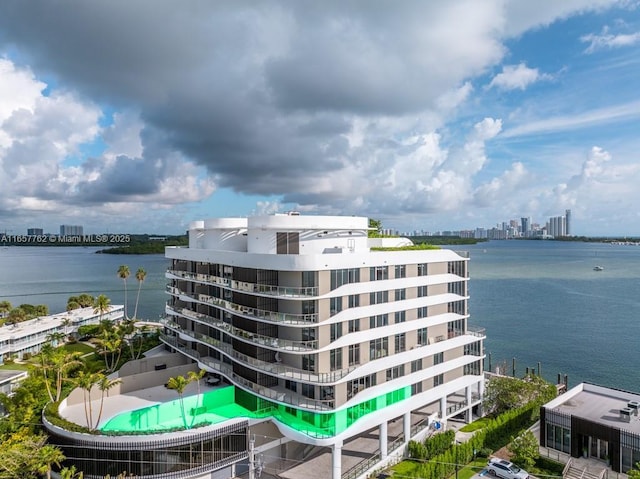 view of building exterior featuring a water view and a view of city