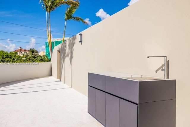 view of property exterior with a sink and stucco siding