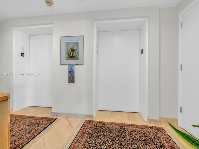 interior space with light tile patterned floors and elevator