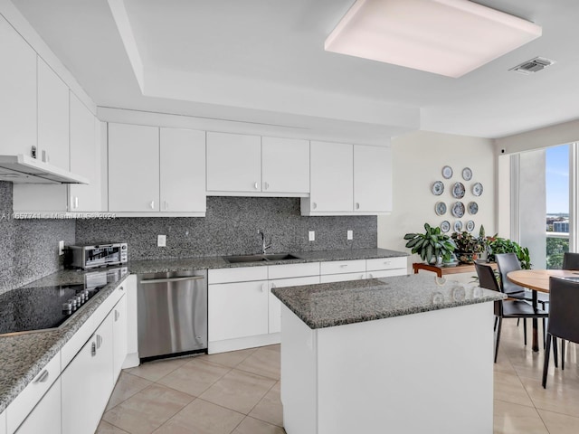 kitchen featuring sink, a kitchen island, backsplash, dishwasher, and black cooktop