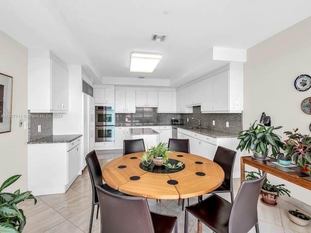 dining area featuring sink and light tile patterned floors