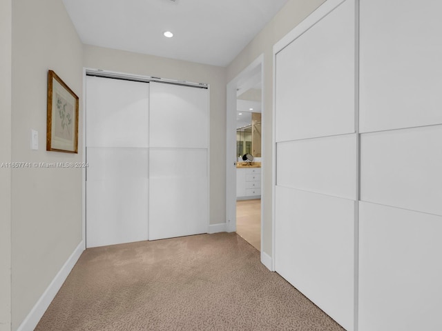 unfurnished bedroom featuring a closet and light colored carpet