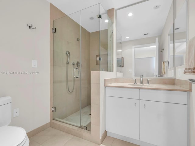 bathroom with vanity, toilet, tile patterned floors, and a shower with shower door