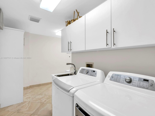 clothes washing area featuring light tile patterned floors, cabinets, sink, and independent washer and dryer