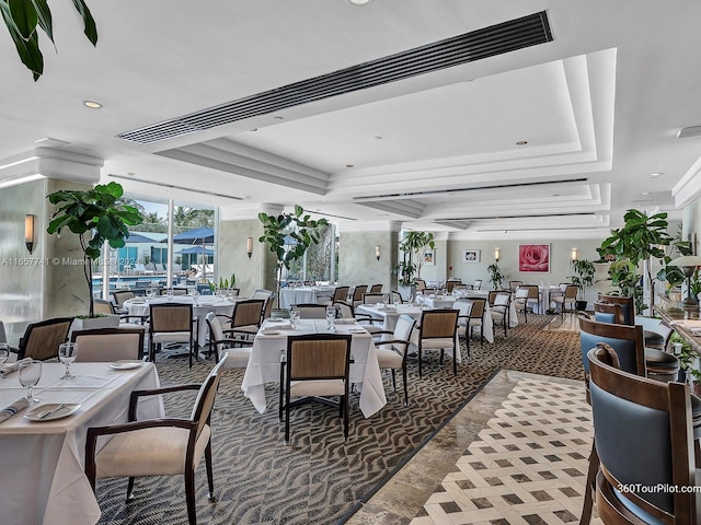 dining space with a raised ceiling