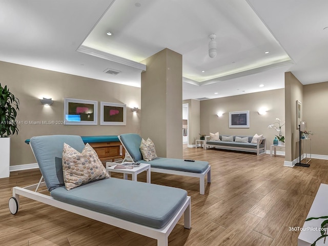 interior space with a tray ceiling and hardwood / wood-style floors