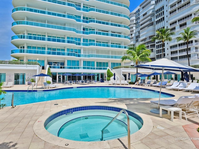 view of pool with a patio area and a hot tub