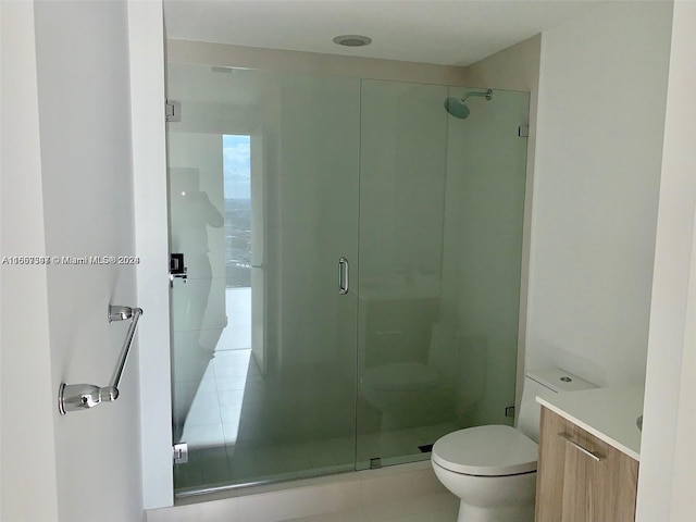 bathroom with vanity, toilet, and a shower with door