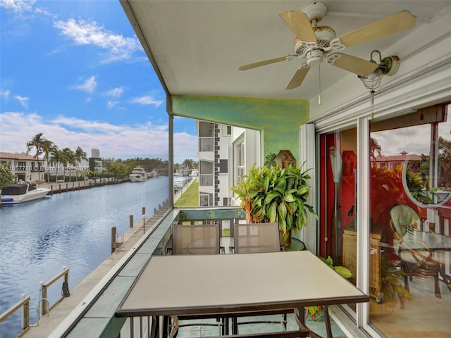 balcony with a water view and ceiling fan