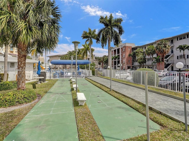 view of home's community featuring shuffleboard and fence