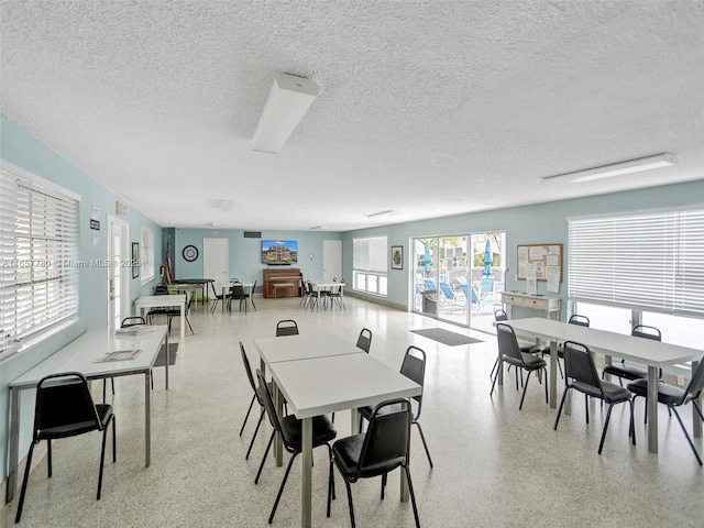 dining space with speckled floor and a textured ceiling