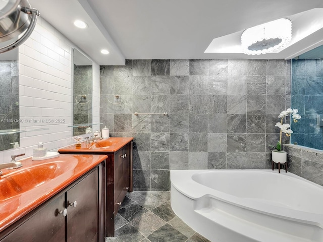 bathroom featuring vanity, a bathtub, and tile walls