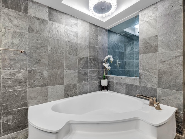 bathroom with a bathtub and tile walls