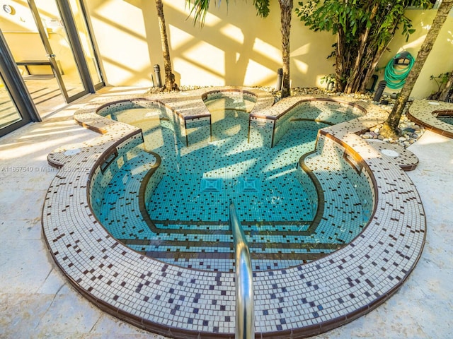 view of pool with a hot tub