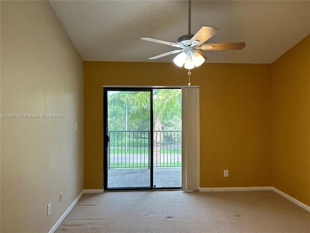 carpeted spare room featuring ceiling fan and a textured ceiling