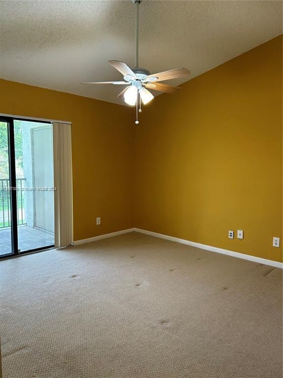 carpeted spare room featuring a textured ceiling and ceiling fan