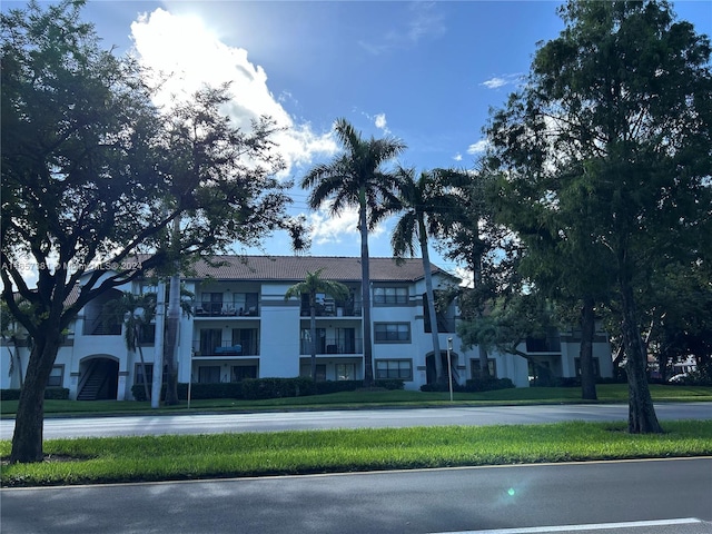 view of front of property featuring a balcony and a front yard