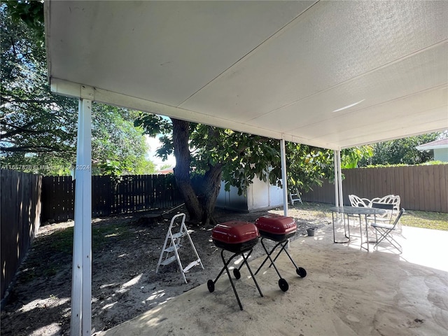 1810 NW 69th Ter, Miami, FL 33147 - view of patio / terrace featuring a fenced backyard, outdoor dining area, an outbuilding, and area for grilling