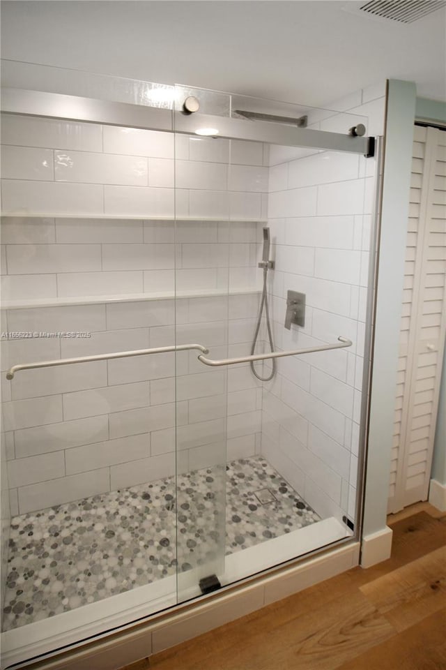 bathroom featuring hardwood / wood-style flooring and an enclosed shower