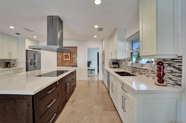 kitchen with dark brown cabinets, island range hood, stainless steel appliances, sink, and white cabinets