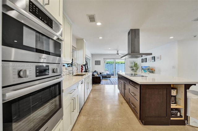 kitchen with white cabinetry, island exhaust hood, dark brown cabinets, and stainless steel double oven