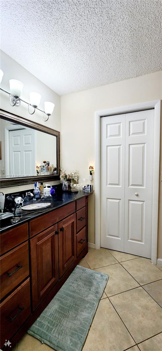 bathroom featuring tile patterned flooring, a textured ceiling, and vanity