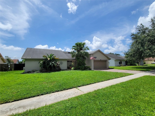 ranch-style house featuring an attached garage, a front lawn, fence, stucco siding, and driveway