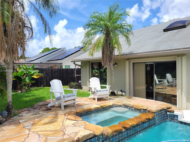 view of pool featuring a patio area, a pool with connected hot tub, and fence