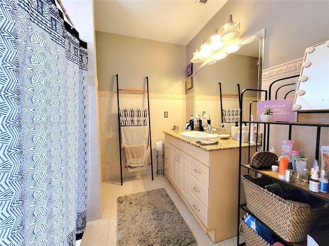 full bath with visible vents, a shower with curtain, wainscoting, tile patterned flooring, and vanity