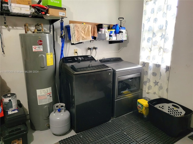 washroom with laundry area, washing machine and dryer, and water heater