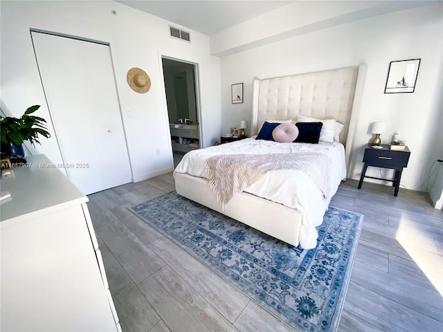 bedroom with ensuite bathroom and a closet