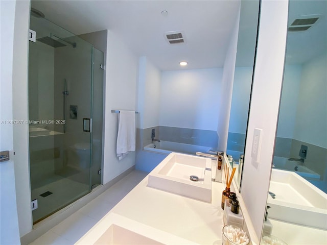 bathroom featuring tile patterned flooring, separate shower and tub, and sink