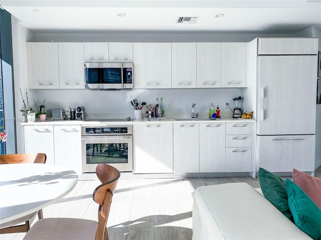 kitchen featuring sink, stainless steel appliances, and white cabinetry