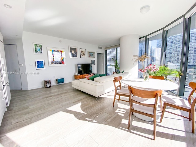 living room with light wood-type flooring and a wall of windows