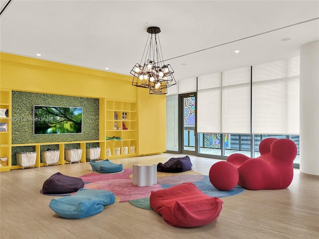 playroom with an inviting chandelier, built in features, and wood-type flooring