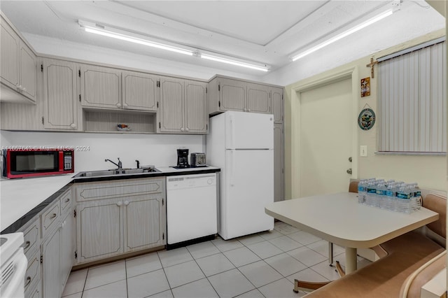 kitchen featuring white appliances, sink, and light tile patterned flooring