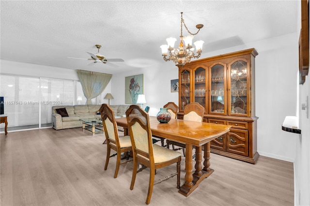 dining area featuring a textured ceiling, light hardwood / wood-style flooring, and ceiling fan with notable chandelier