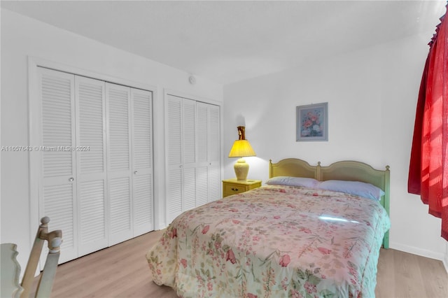 bedroom with hardwood / wood-style flooring and two closets