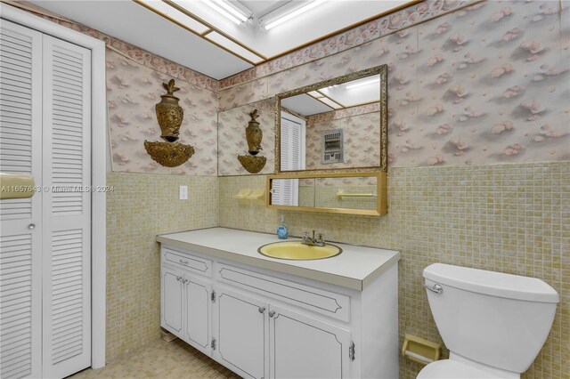 215 SE 3rd Ave Unit 407B, Hallandale Beach, FL 33009 - bathroom with a wainscoted wall, wallpapered walls, toilet, and tile walls