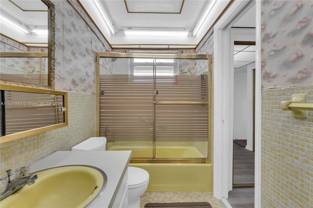 215 SE 3rd Ave Unit 407B, Hallandale Beach, FL 33009 - full bath featuring wallpapered walls, toilet, tile walls, and wainscoting