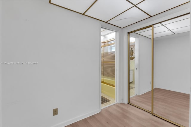 unfurnished bedroom with light hardwood / wood-style flooring and a closet