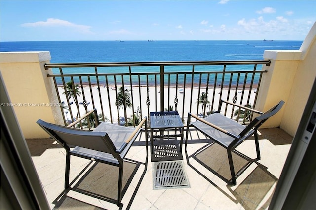 balcony featuring a view of the beach and a water view