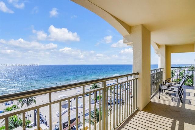 balcony featuring a water view and a beach view