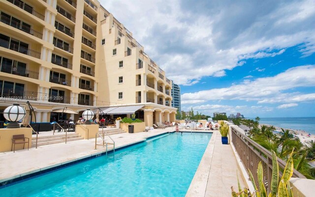 view of pool featuring a patio area and a water view