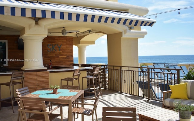 balcony with a water view and ceiling fan