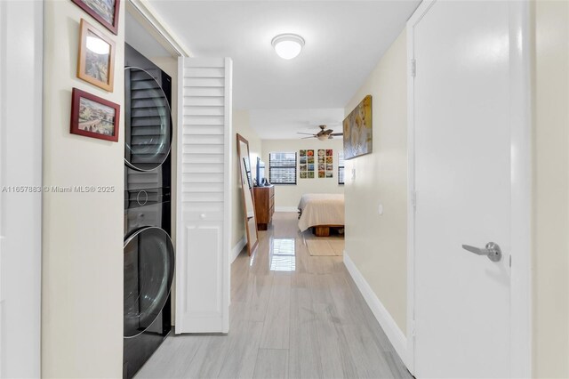 hall featuring light hardwood / wood-style floors and stacked washing maching and dryer