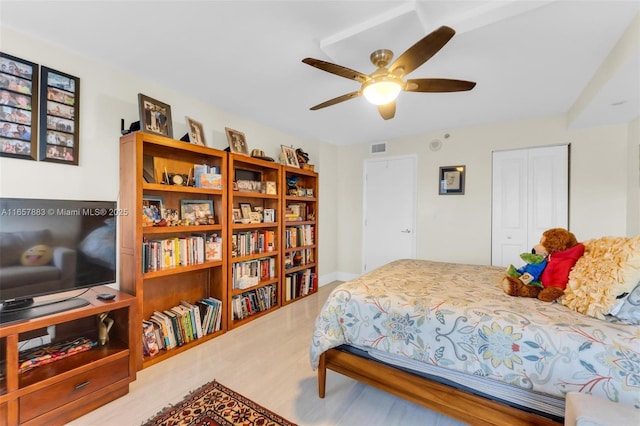 bedroom with light hardwood / wood-style flooring, a closet, and ceiling fan