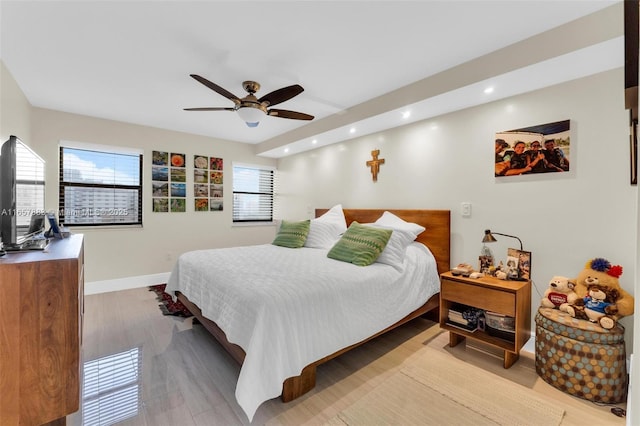 bedroom with light hardwood / wood-style floors and ceiling fan