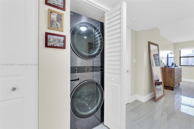 clothes washing area featuring stacked washer and clothes dryer